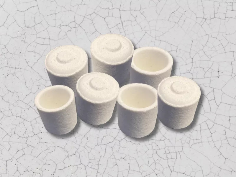 Photo of many white ceramic crucibles with a ceramic background