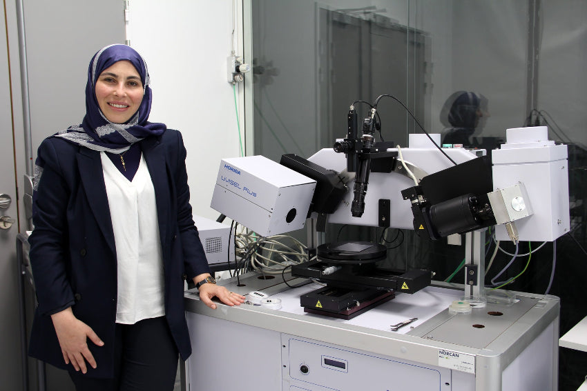 Photo of our Expert Rana OMAR with an Uvisel Plus Ellipsometer instrument in the laboratory
